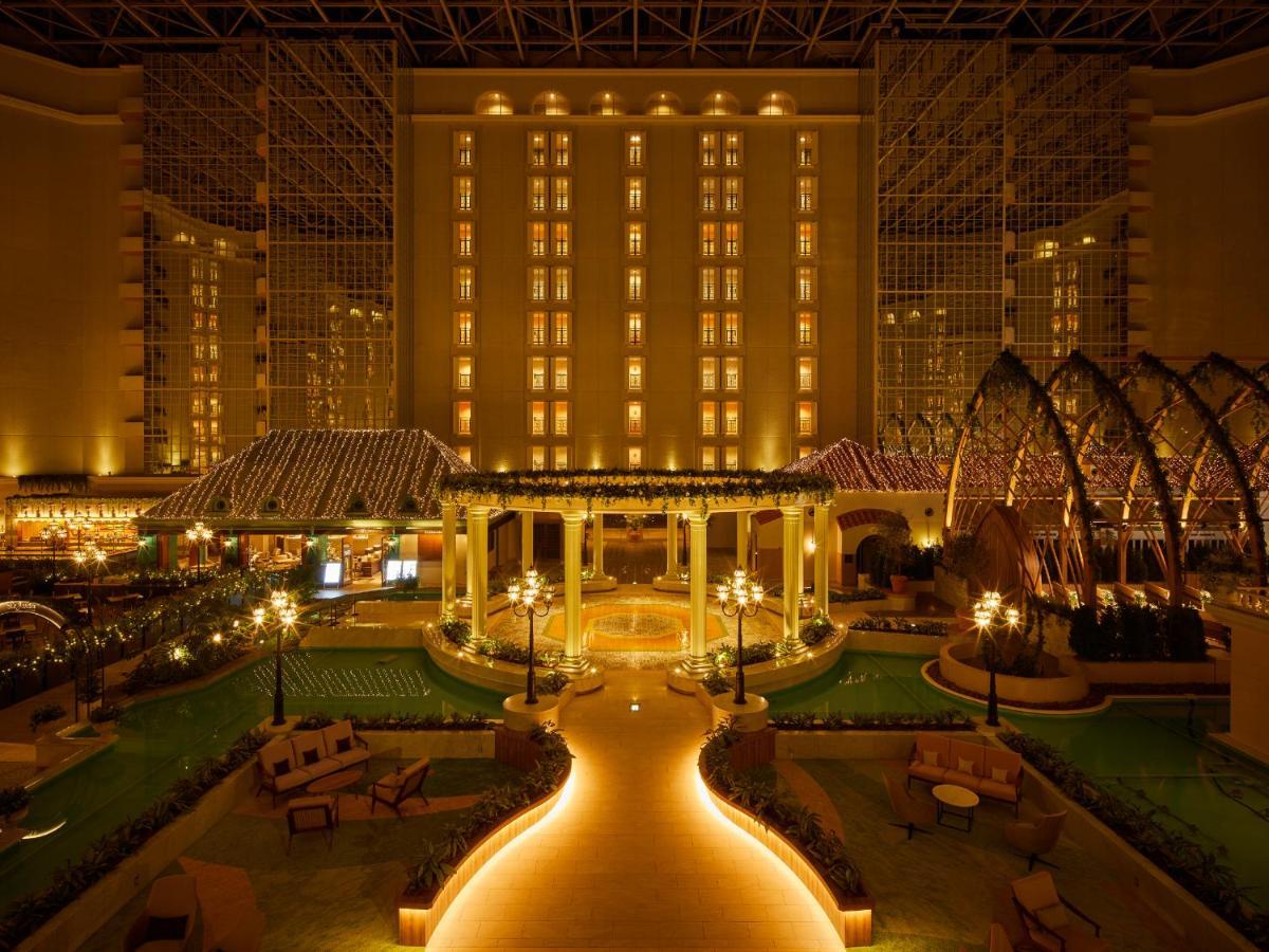 Hotel Grand Nikko Tokyo Bay Maihama Urayasu Esterno foto The photo shows a beautifully illuminated indoor space resembling a luxury hotel or resort. There are elegant architectural features, including large columns, arches, and decorative lighting. The area is designed with lush greenery and well-maintaine