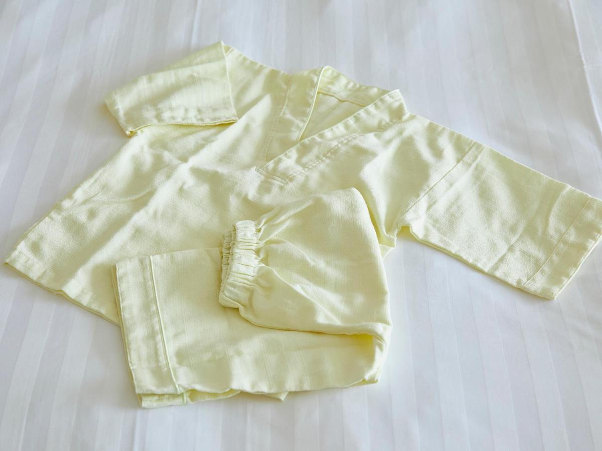 Hotel Grand Nikko Tokyo Bay Maihama Urayasu Esterno foto The photo shows a small, traditional outfit made of light yellow fabric. The outfit includes a short-sleeved top with a V-neck and a pair of matching pants. The design is simple, featuring a loose fit and a comfortable style, making it suitable for c