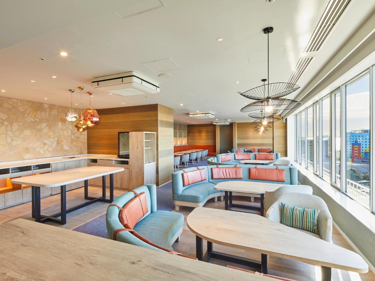 Hotel Grand Nikko Tokyo Bay Maihama Urayasu Esterno foto The photo shows a modern and stylish lounge or café area with large windows allowing natural light to fill the space. The interior features comfortable seating arrangements with sofas and tables, predominantly in soft colors, including shades of blue
