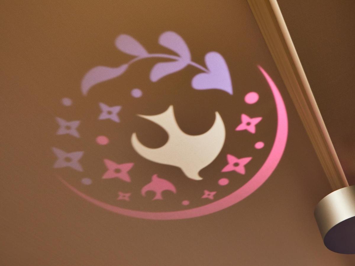 Hotel Grand Nikko Tokyo Bay Maihama Urayasu Esterno foto The image shows a projection on a surface, featuring a circular design with a mix of colors, primarily pink and purple. The design includes a white dove, which is likely a symbol of peace, surrounded by decorative elements such as leaves and small st