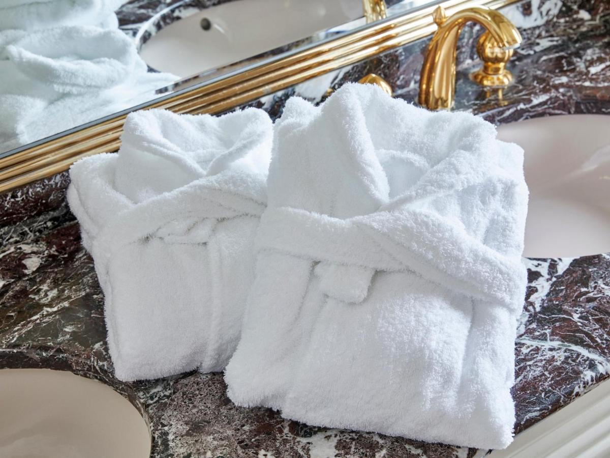 Hotel Grand Nikko Tokyo Bay Maihama Urayasu Esterno foto The photo shows two white bathrobes neatly folded and placed on a marble surface, likely in a luxurious bathroom setting. The bathrobes have a simple, classic design with belts tied around them. In the background, there appears to be a decorative mir