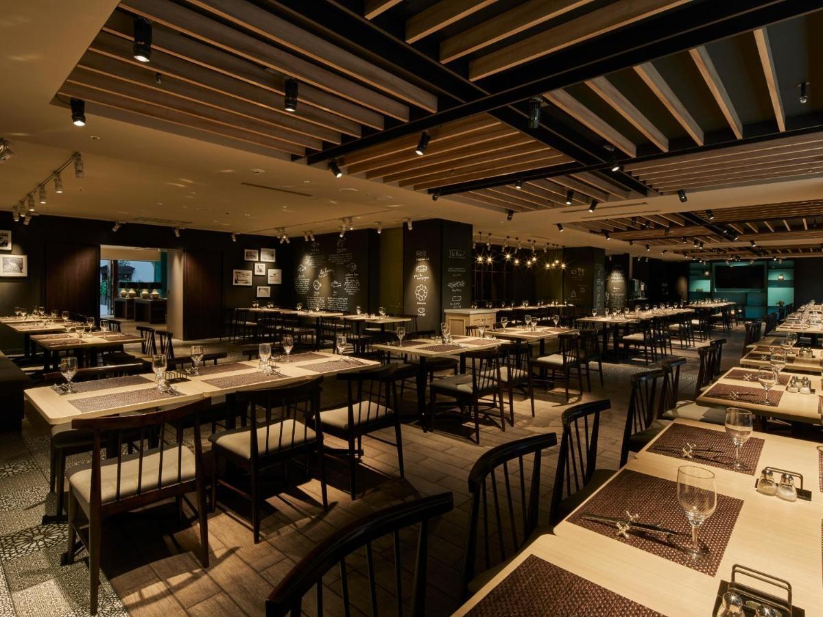 Hotel Grand Nikko Tokyo Bay Maihama Urayasu Esterno foto The photo shows the interior of a modern restaurant. The space features a spacious dining area with several long tables arranged in rows. Each table is set with dining utensils, plates, and glasses, indicating readiness for patrons. The lighting is s