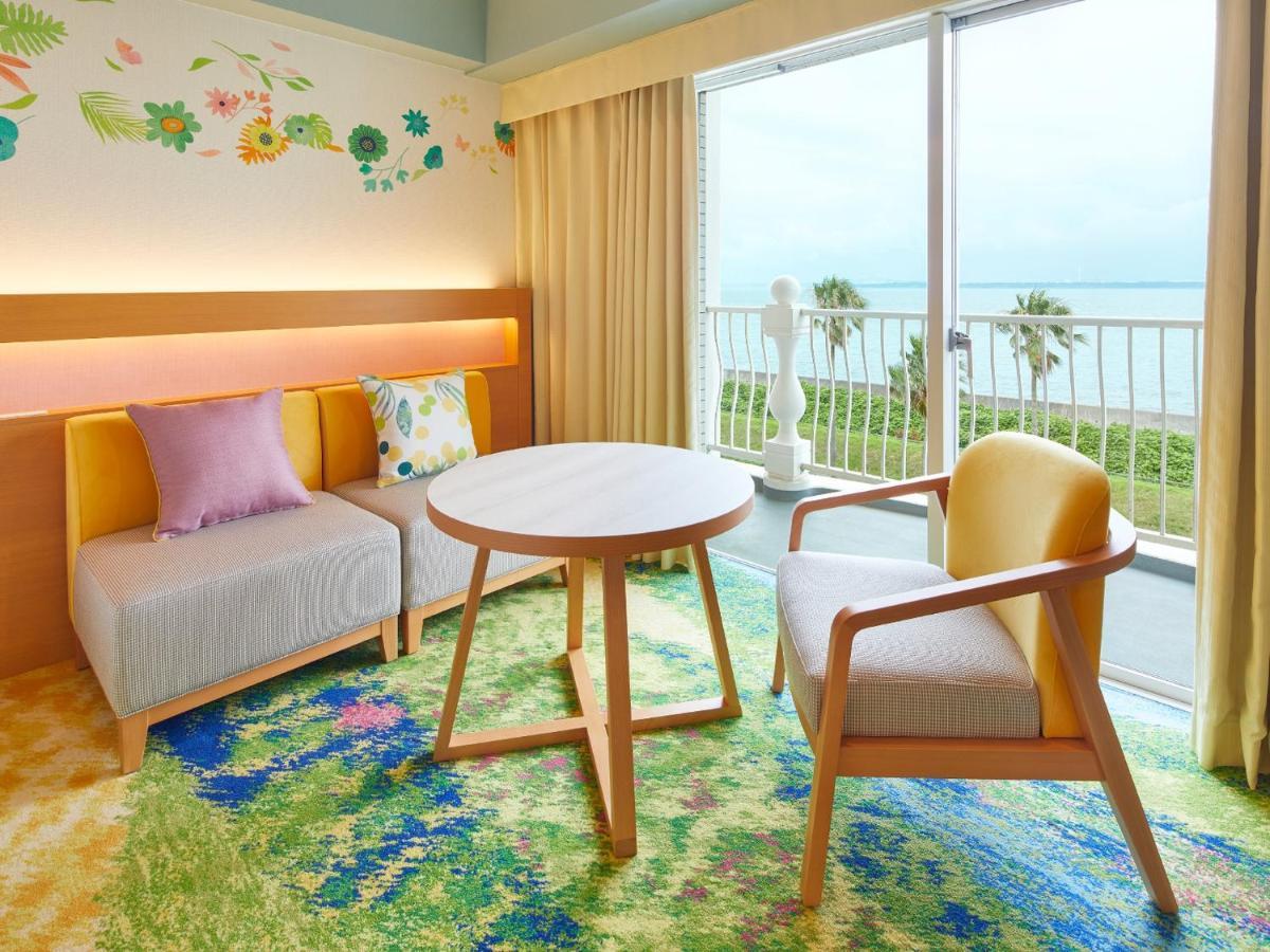 Hotel Grand Nikko Tokyo Bay Maihama Urayasu Esterno foto The photo shows a cozy interior space, likely a hotel room or a lounge area. It features a small round table in the center surrounded by comfortable seating. There are two chairs: one is a light wooden frame with a yellow seat, and the other has a mo