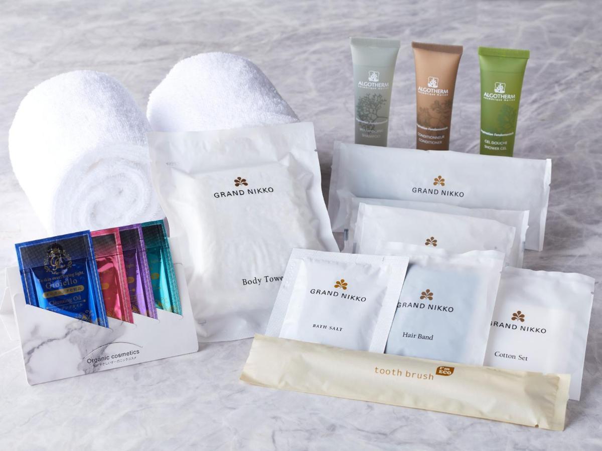 Hotel Grand Nikko Tokyo Bay Maihama Urayasu Esterno foto The photo displays a collection of spa or hotel toiletries. It includes:

- Two fluffy white towels.
- Multiple packages labeled "GRAND NAKO," which appear to be spa or body care products.
- Several small tubes of hair and body care items in green an