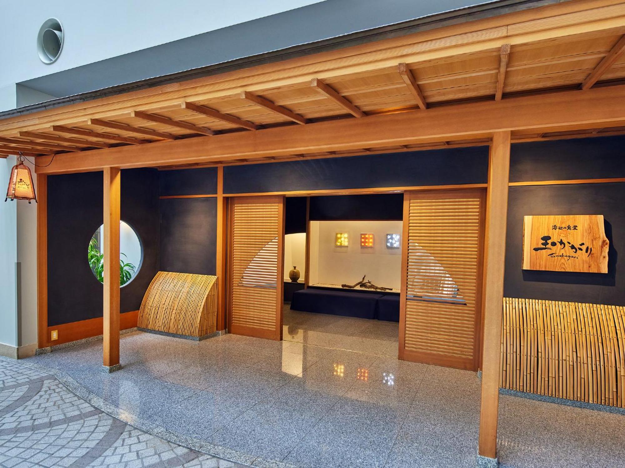 Hotel Grand Nikko Tokyo Bay Maihama Urayasu Esterno foto The photo shows the entrance of a building, designed in a traditional Japanese style. It features a wooden structure with a large overhanging roof and sliding doors. The entrance is flanked by rounded windows, and there's a decorative sign with Japan